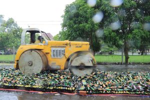 Alat berat menggilas ribuan botol miras hasil Operasi Pekat Polres Indramayu jelang Tahun Baru 2026 di halaman Mapolres Indramayu, Rabu (31/12/2025)