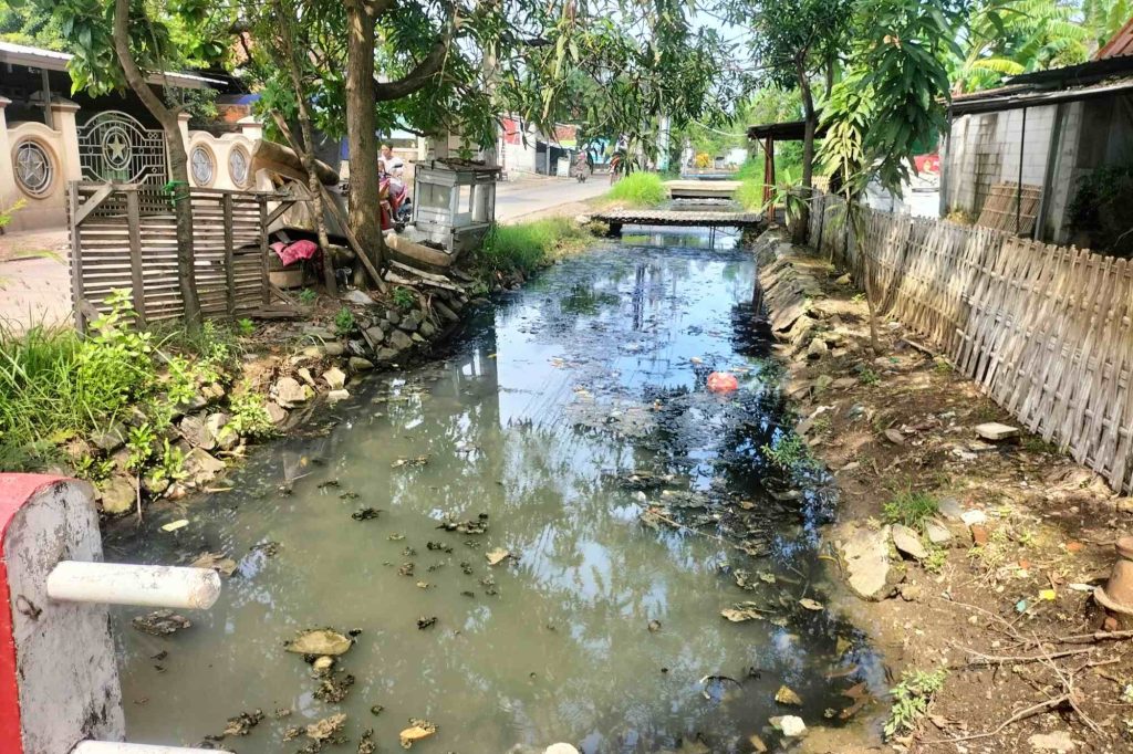 Kondisi saluran air dangkal dan keruh di sepanjang Jalan Tembaga