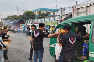 Anggota 234 SC PC Cileunyi membagikan paket takjil kepada pengendara di wilayah Cileunyi, Bandung Timur saat kegiatan sosial Ramadhan.