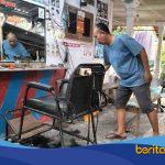 Sukardi, tukang cukur di Pangkas Rambut BSI Bojongsari Indramayu, sedang mencukur pelanggan di tempat usaha sederhana miliknya.